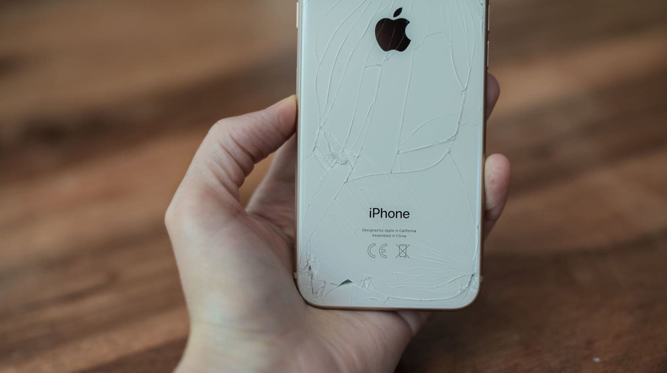 iPhone背面ガラス全体に蜘蛛の巣状のヒビが広がりガラス片が剥離した中度の破損例