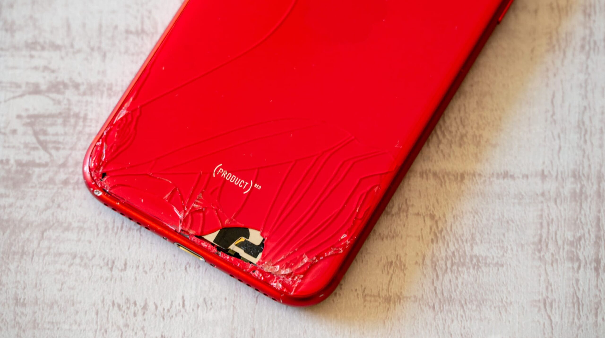 iPhone背面ガラスが大きく割れて内部パーツが露出した重度の破損例