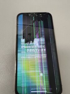 落下により画面割れと液晶漏れが併発したiPhoneの実物写真。画面にカラフルな縦線が多数走っている状態